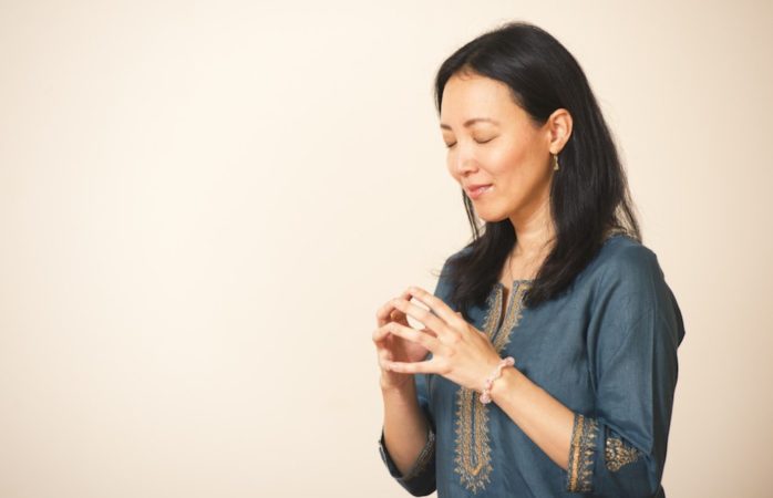真理先生が目をつむり両手の指通しを合わせて合掌している